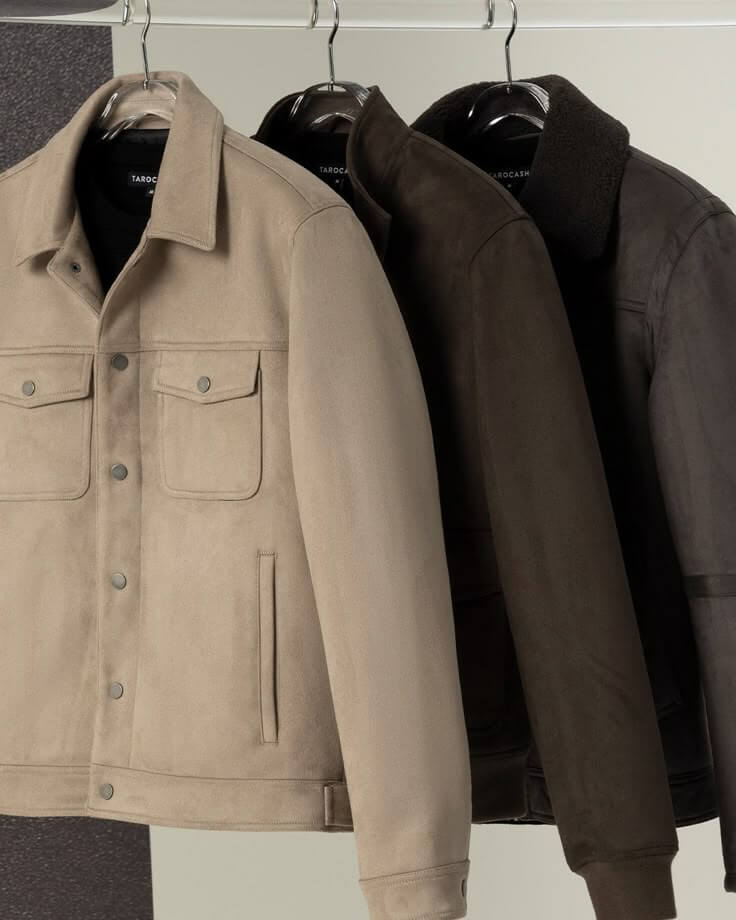 Three stylish coats hanging on hangers: beige, dark brown, and charcoal jackets for modern fashion.