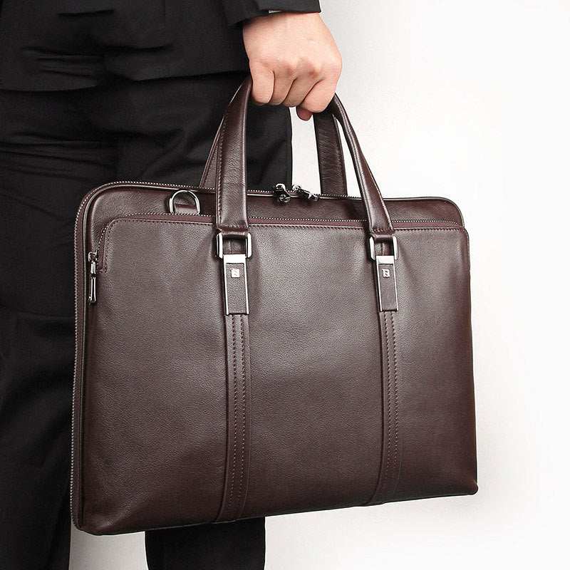 Man holding a leather business briefcase in dark brown, showcasing a stylish and professional design.
