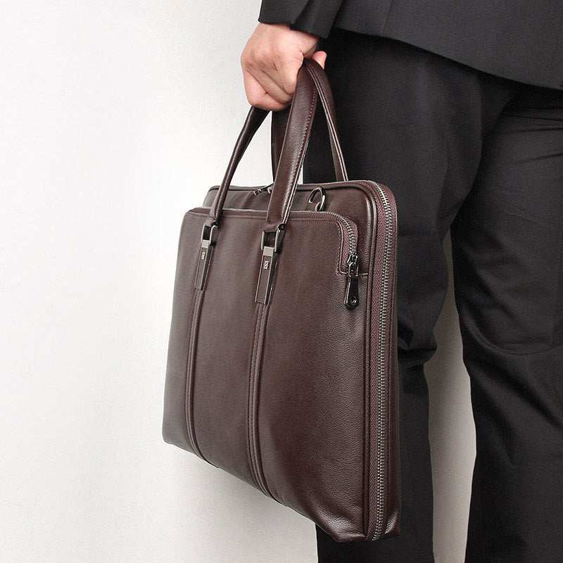 Leather business briefcase held by a man in a suit, showcasing its elegant design and durable material.