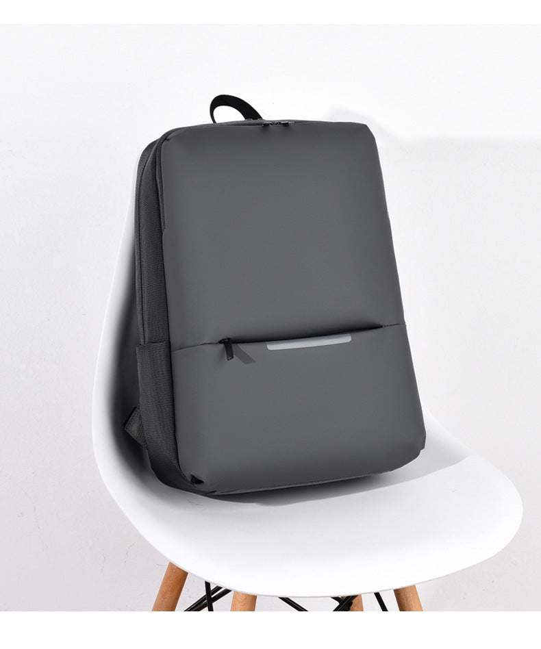 large-capacity business laptop backpack in sleek black design on a minimalist chair.