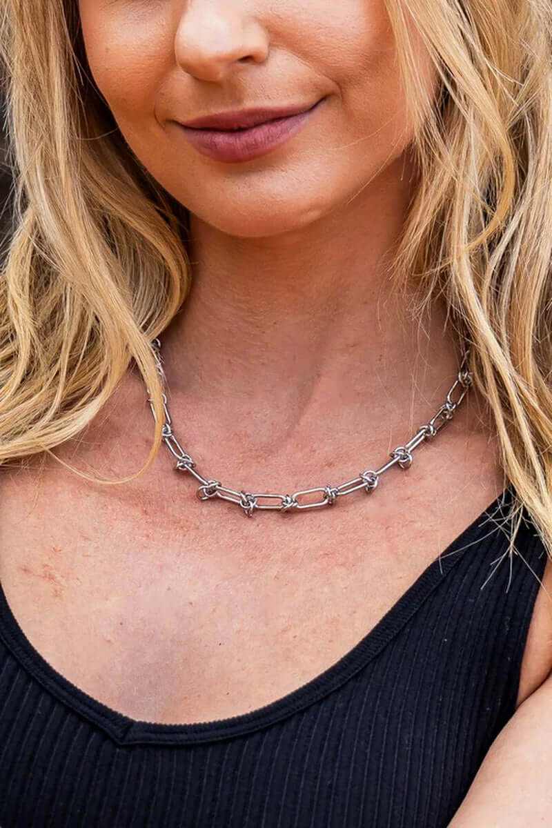 18k stainless steel barbed wire necklace worn by woman with blonde hair and black top