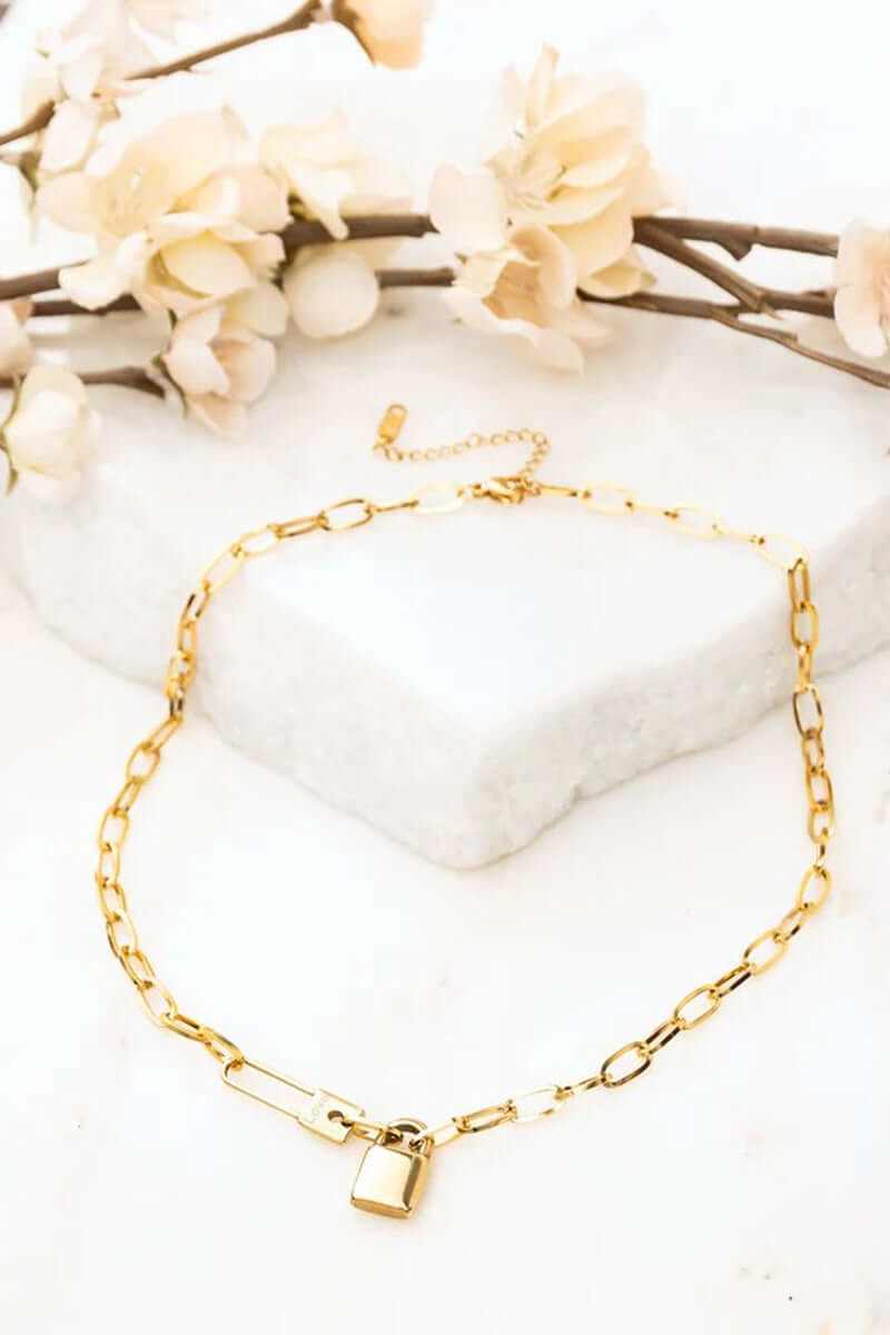 18K stainless steel lock and clip chain necklace on marble with flowers, tarnish resistant, lobster clasp, everyday wear.