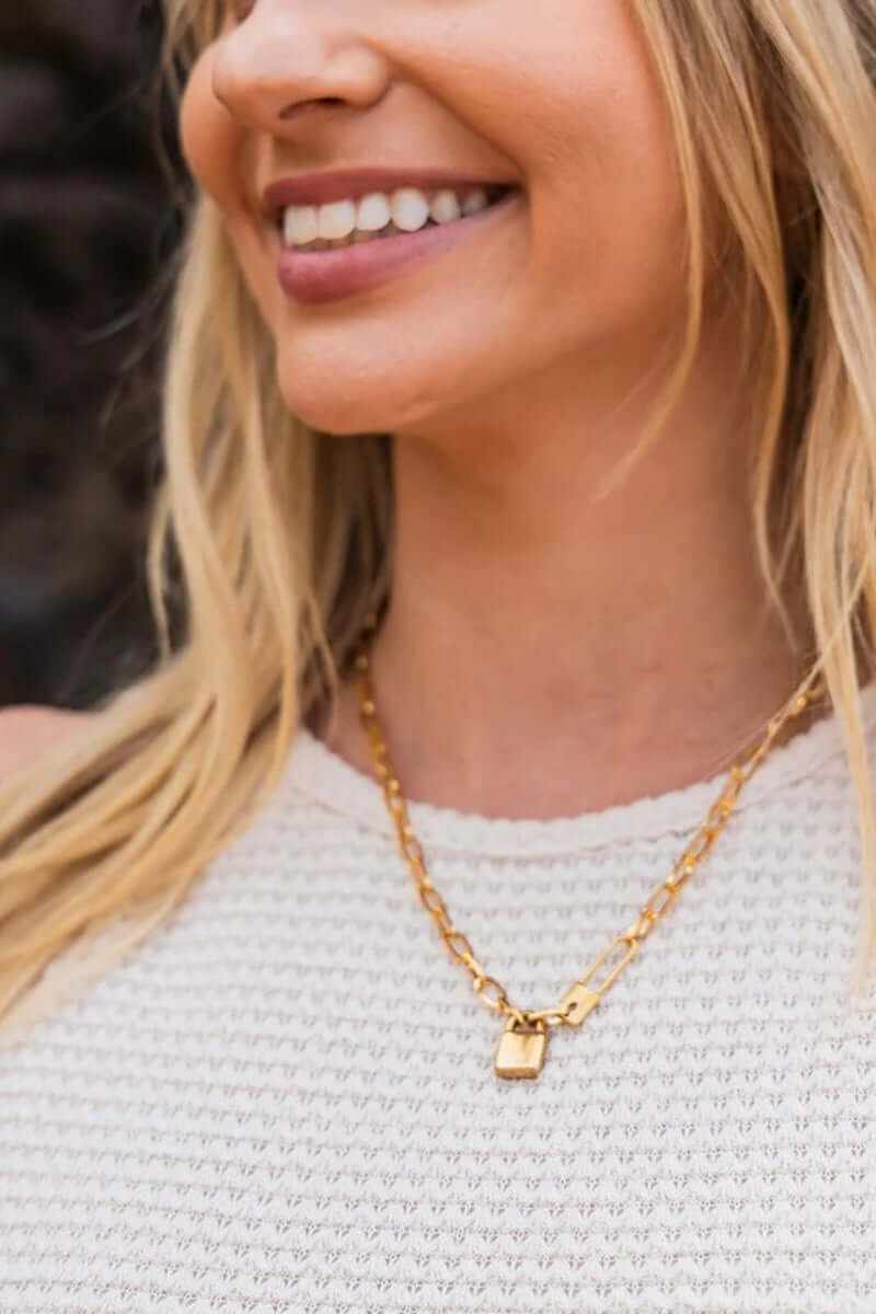 Model wearing an 18K stainless steel lock and clip chain necklace, showcasing its gold plating and stylish design.