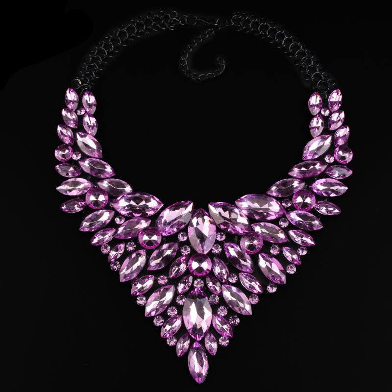 Pink diamond-studded alloy necklace with water drop shaped crystals on black background