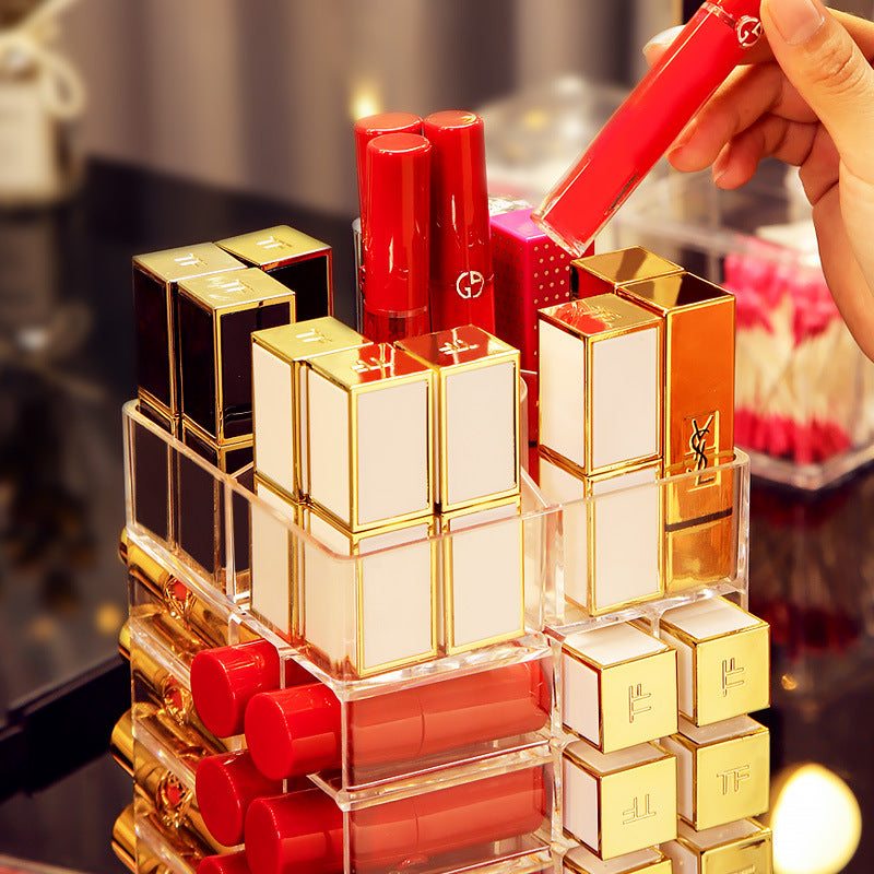 Clear acrylic lipstick storage box organizer holding multiple lipsticks and lip glosses on a vanity table
