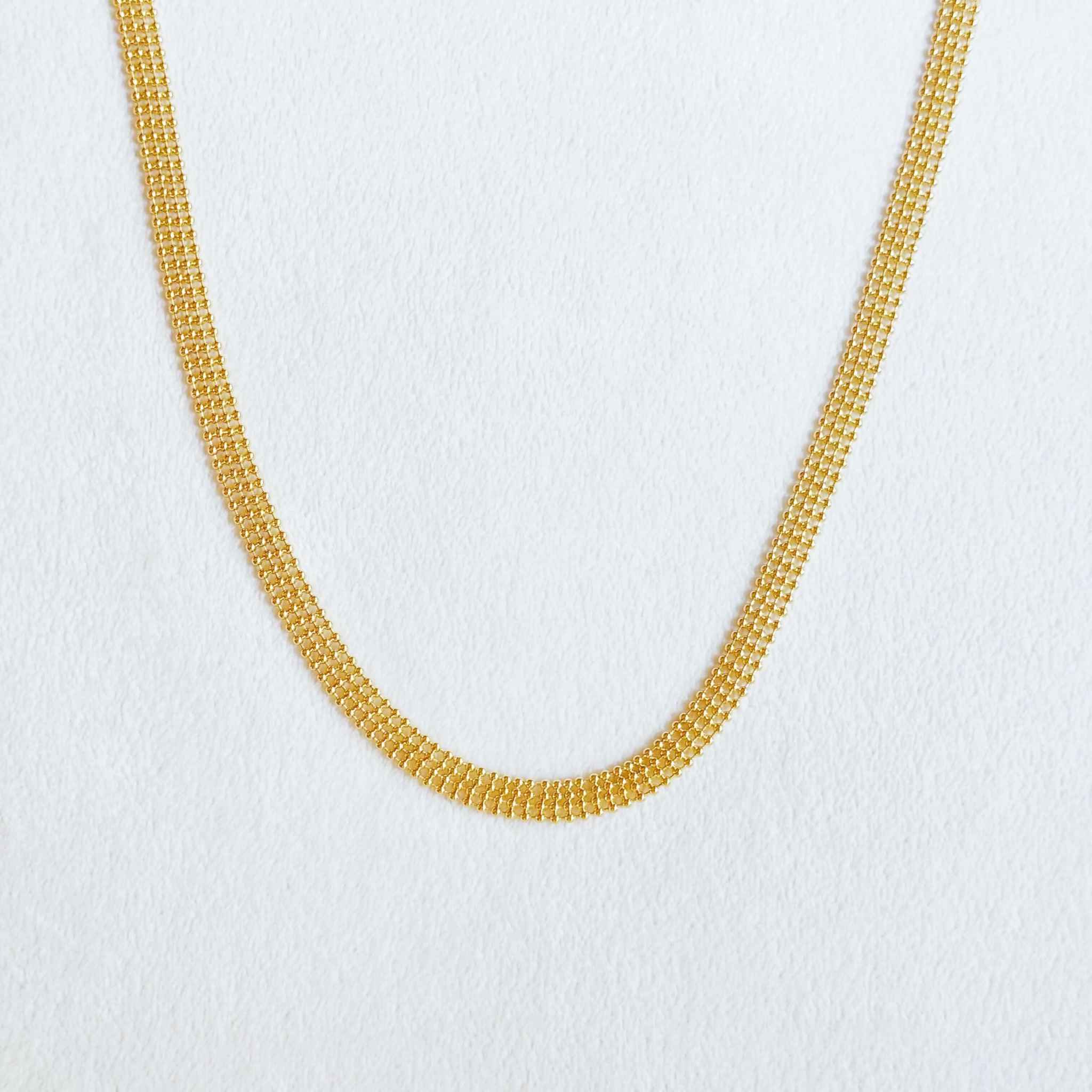 Adjustable gold choker necklace with layered bead design, stylish accessory for versatile looks.