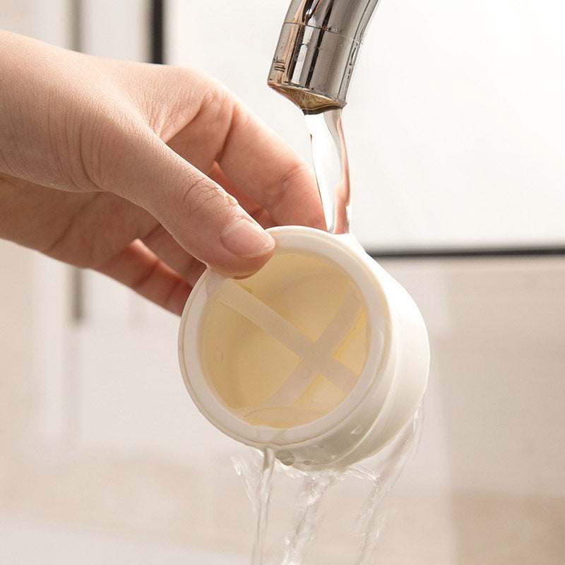Hand washing a white plastic Beauty Egg Stand cosmetics storage rack under running water for cleaning and dustproof maintenance