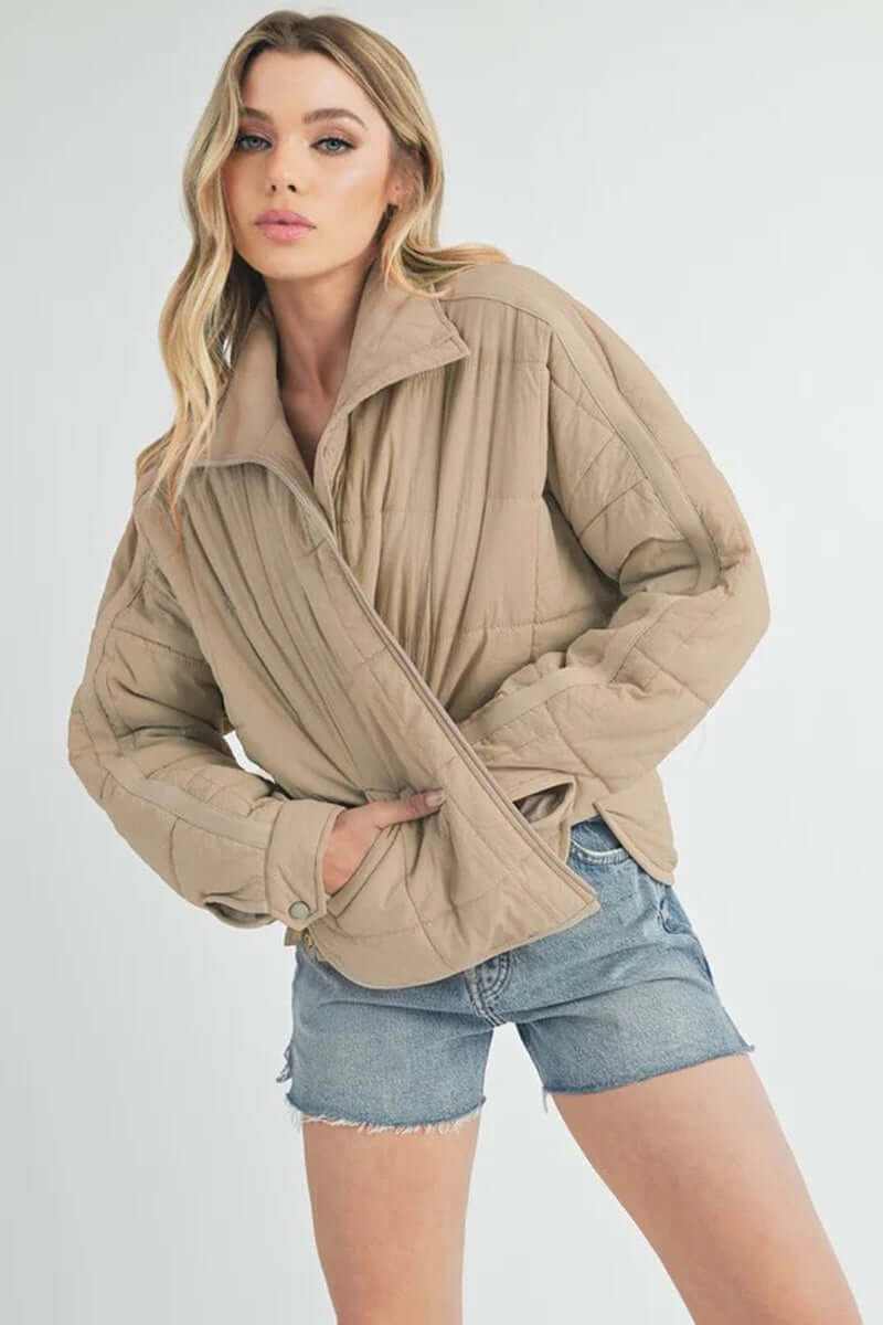 Bebe puffer jacket in beige on a model, featuring oversized silhouette and trendy, casual styling.