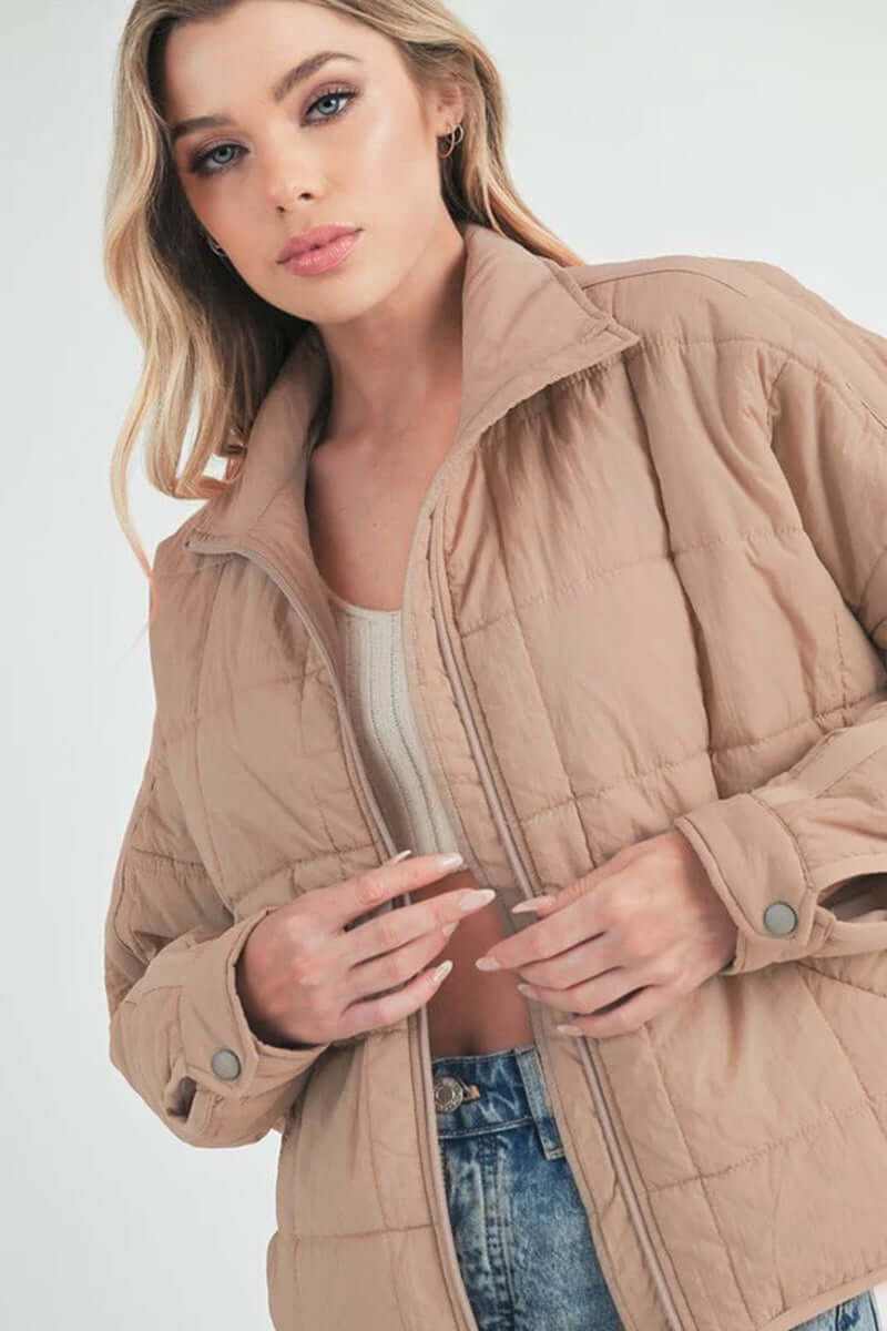 Bebe puffer jacket featuring a boxy silhouette and snap button cuffs, ideal for travel and winter outings.