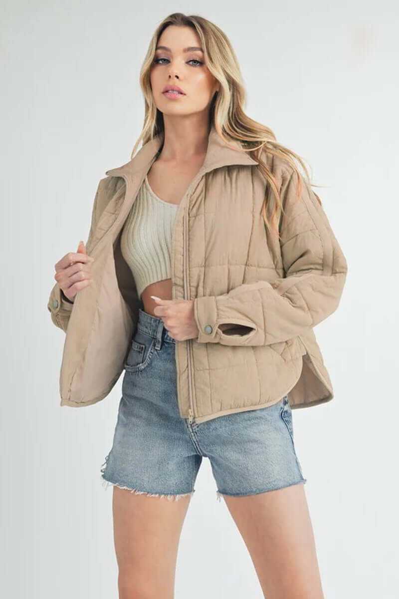 Bebe puffer jacket in beige, styled with a cropped knit top and denim shorts, perfect for casual outings.