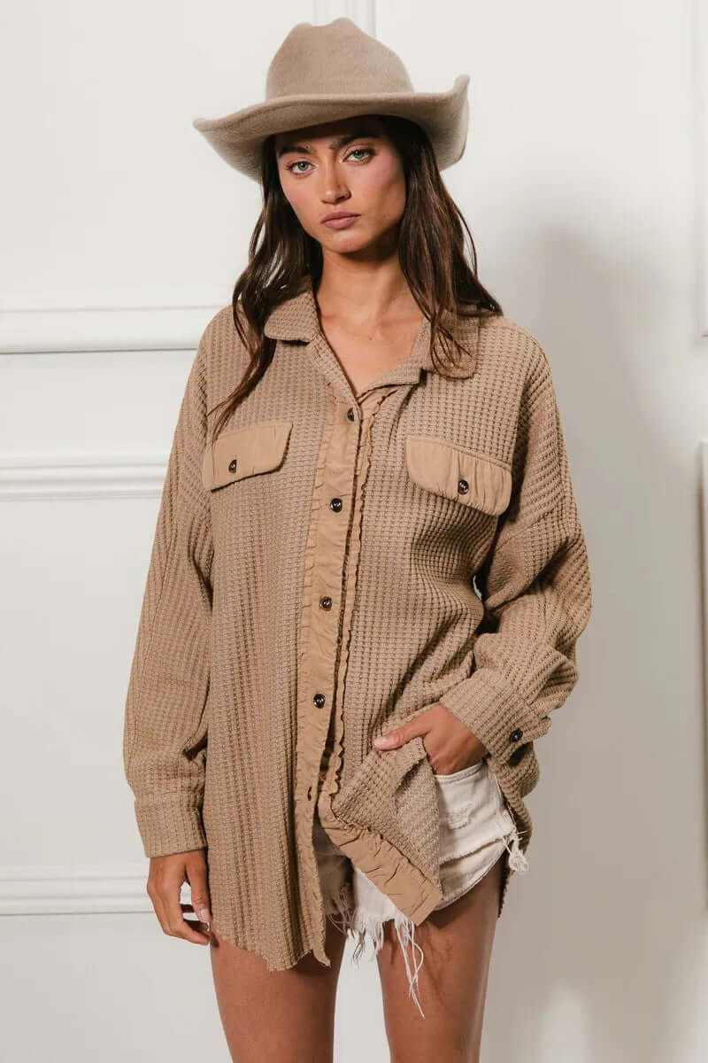Model wearing Bibi Heavy Waffle Oversized Shacket in beige, styled with a hat and shorts for a trendy outfit.