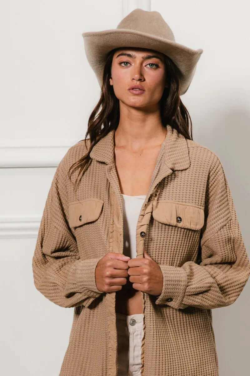 Model wearing a Bibi Heavy Waffle Oversized Shacket in beige, styled with a hat and a casual outfit for a chic look.
