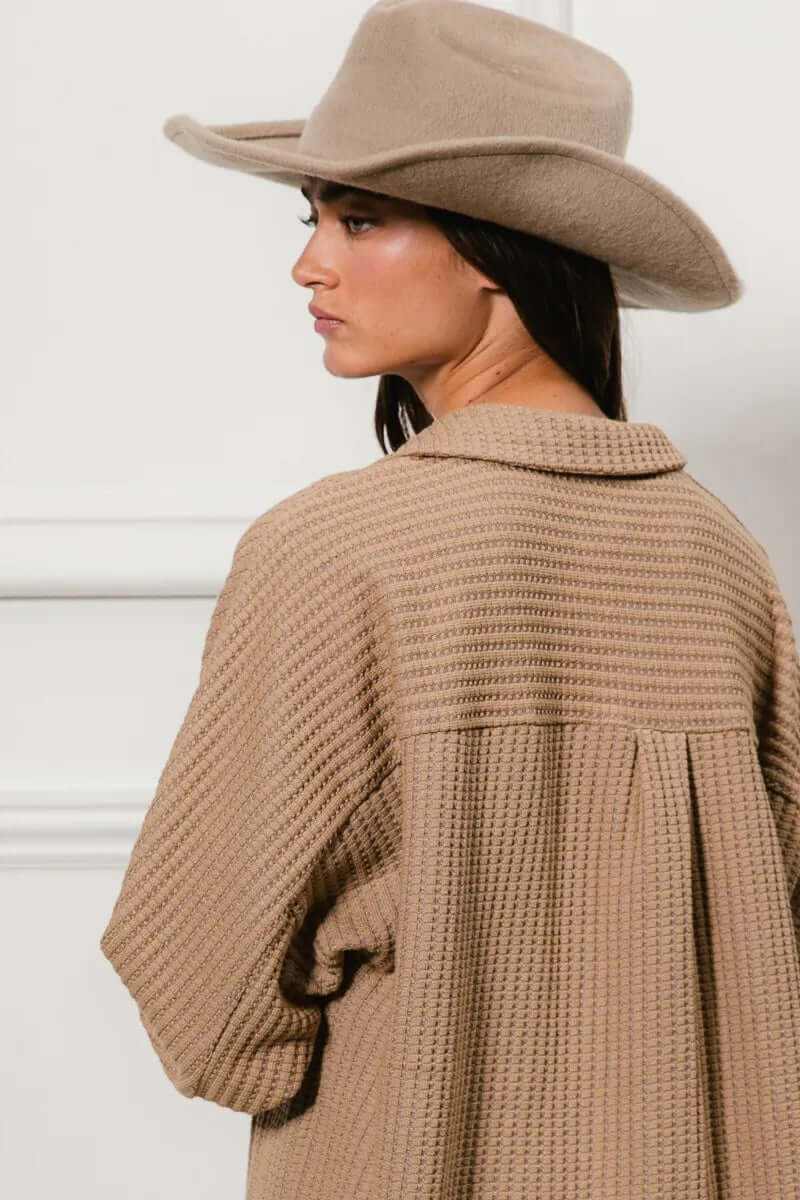 Model wearing a beige heavy waffle oversized shacket with a wool hat, showcasing a stylish casual look.