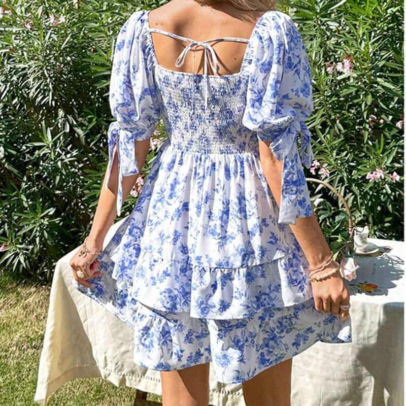 Back view of women's puff sleeve floral mini dress with smocked bodice and ruffle hem, perfect for summer outfits.