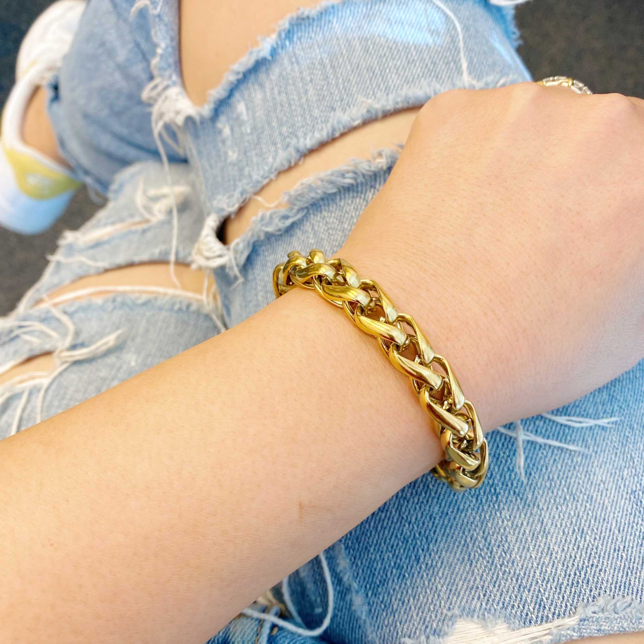 Bold and edgy 18k gold plated chain bracelet worn on a stylish arm with distressed denim.