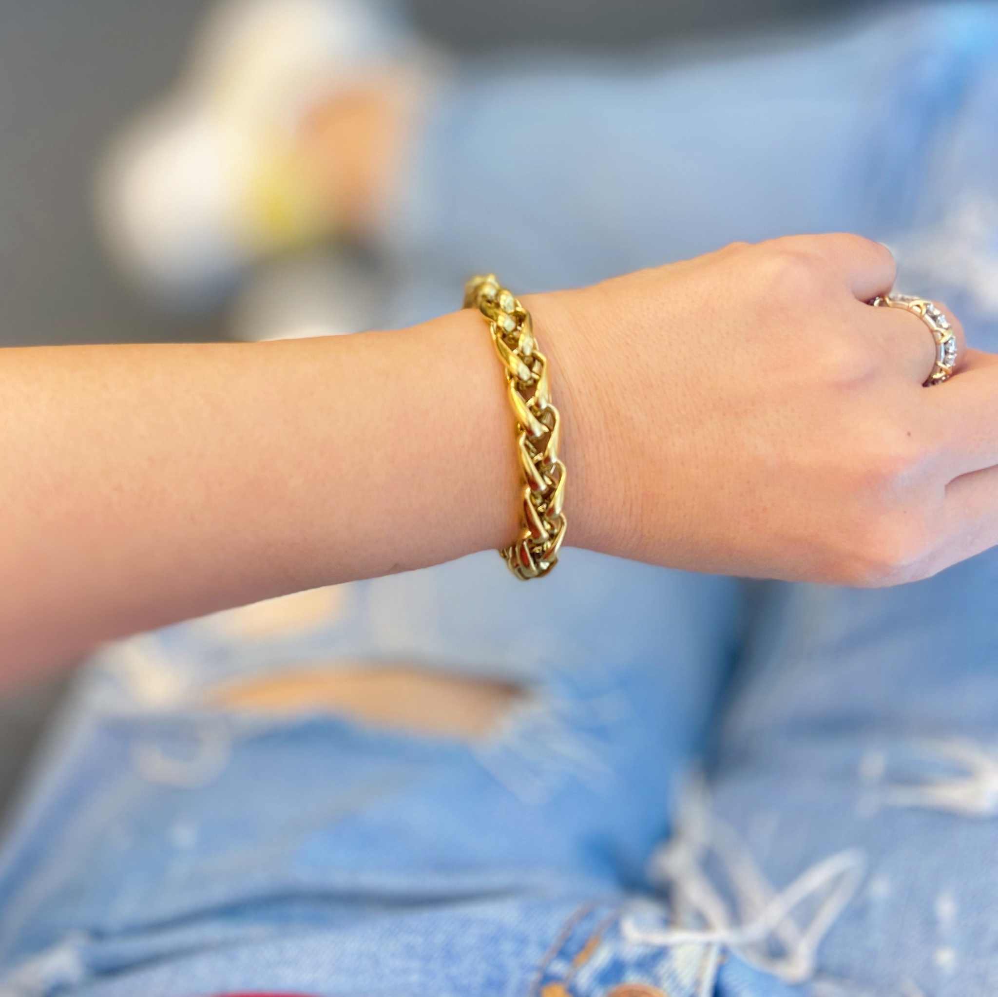 Bold and edgy gold chain bracelet worn on wrist, perfect for styling alone or layering. Chic design with small links.