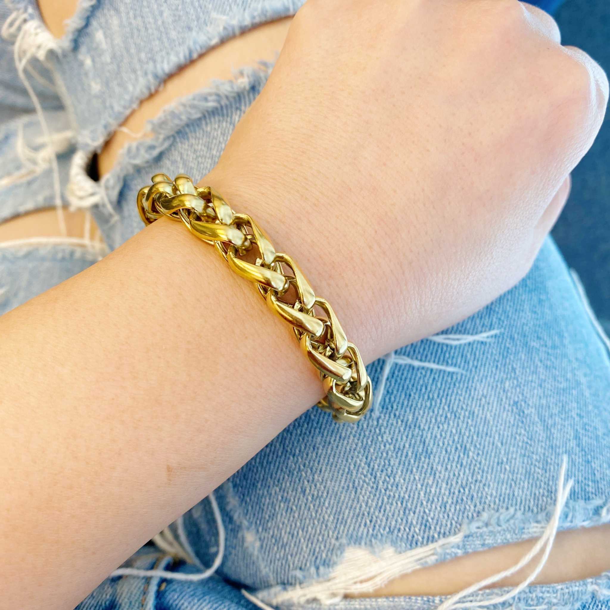 Bold and edgy gold chain bracelet on a wrist, showcasing small links and a chic design. Perfect for layering.