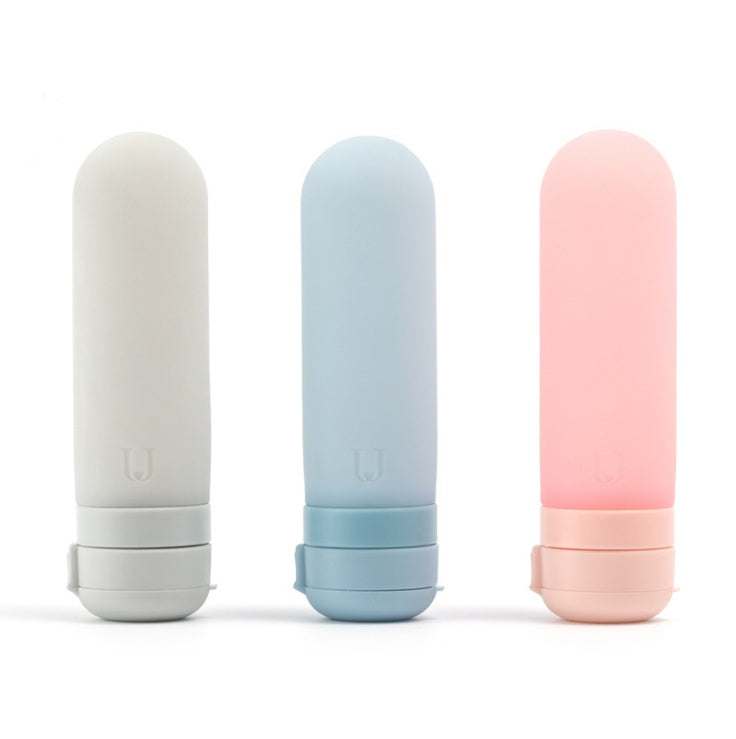 Set of three silicone bottled travel cosmetics in gray, blue, and pink colors for storage and convenience.