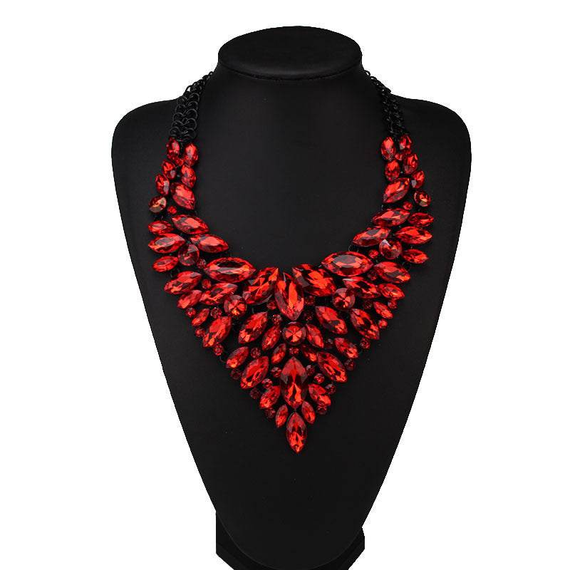 Red diamond-studded water drop shaped alloy necklace on black display stand