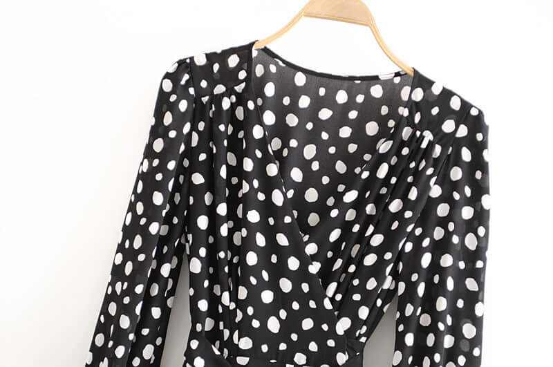 Black chiffon long sleeve dress with white polka dots, showcasing a split wrap design and elegant styling.