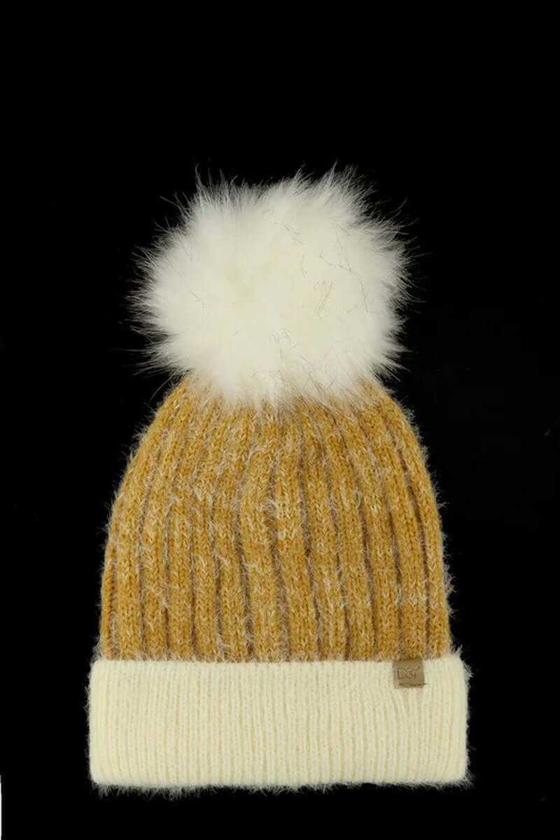 Chunky knit faux fur pom beanie in mustard yellow and cream, perfect for winter warmth and style.