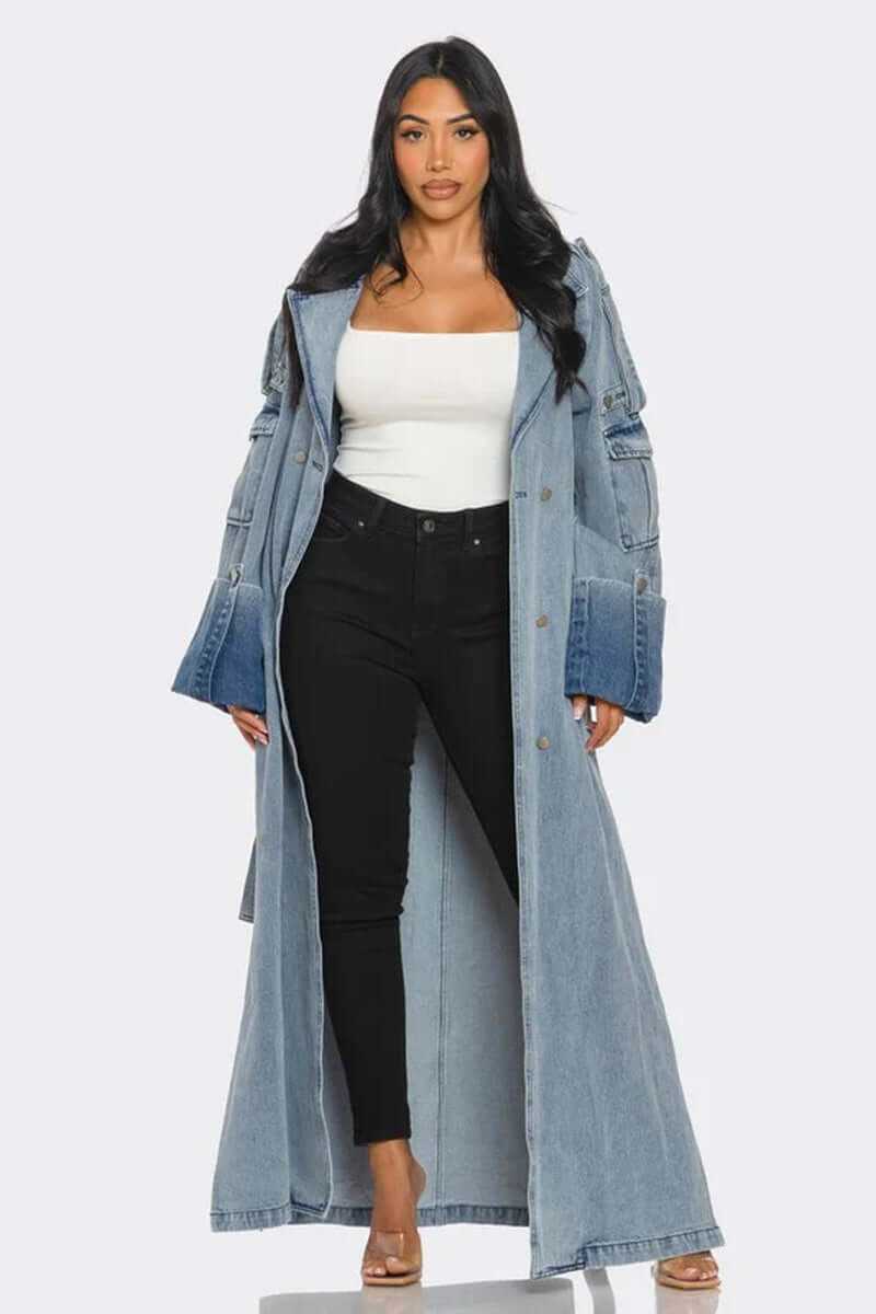 Woman wearing classic longline denim trench coat with wide lapels and oversized cuffs