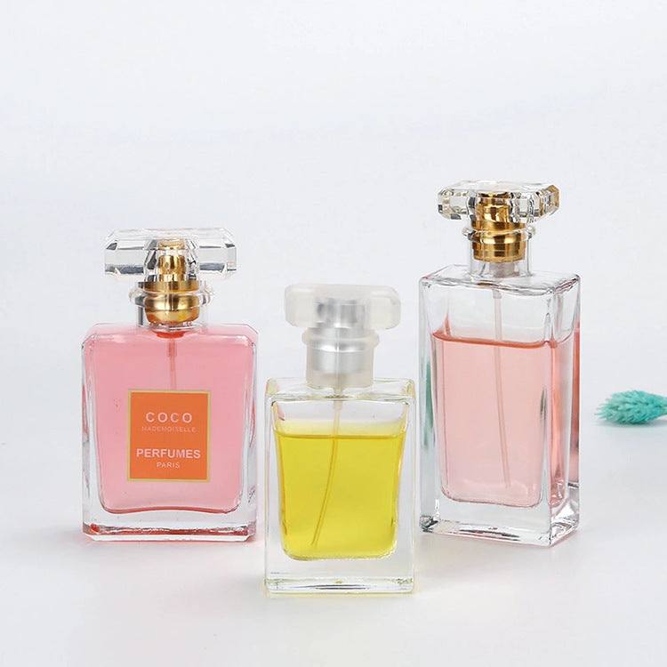 Clear glass perfume bottles with acrylic caps containing pink and yellow perfume liquids