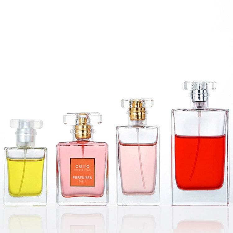 Clear glass perfume bottles in various sizes with acrylic caps for cosmetics packaging