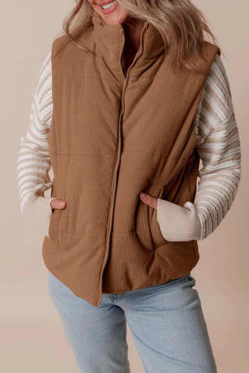 Stylish woman modeling a coffee corduroy stand neck zipped puffer vest with cozy sweater sleeves.