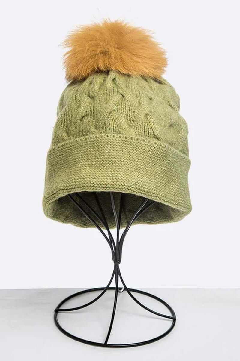 Cuffed slouchy beanie in olive green with a fluffy fur pom for stylish winter warmth.
