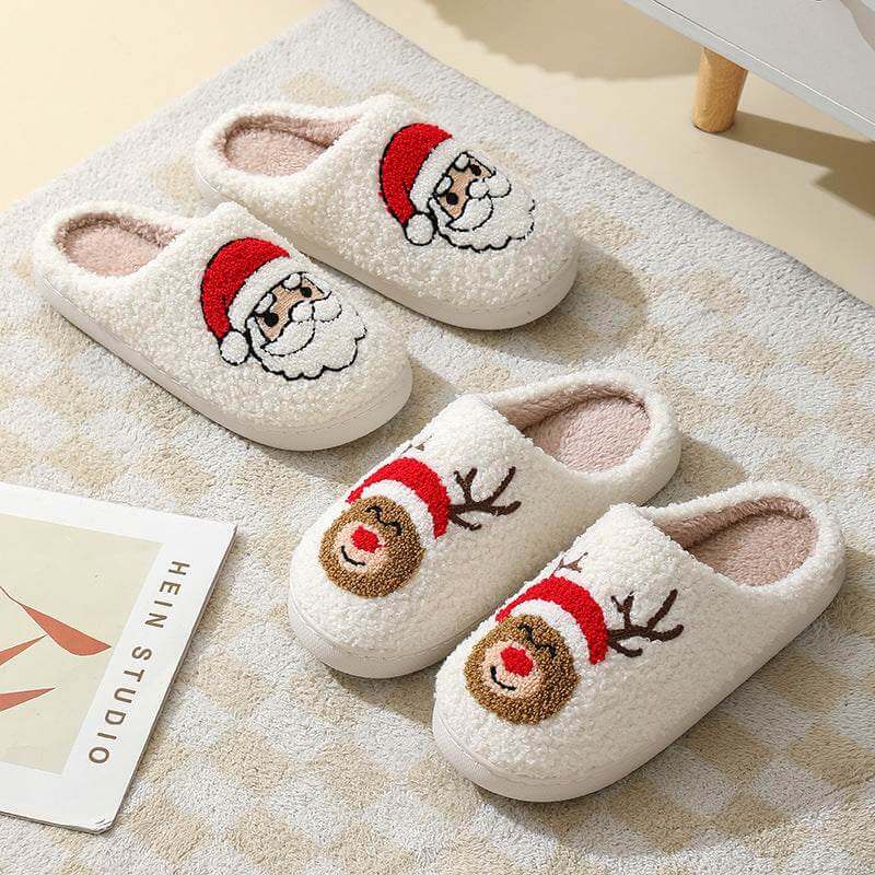 Pair of cozy Santa Claus slippers and reindeer slippers in white plush material on a beige checkered rug
