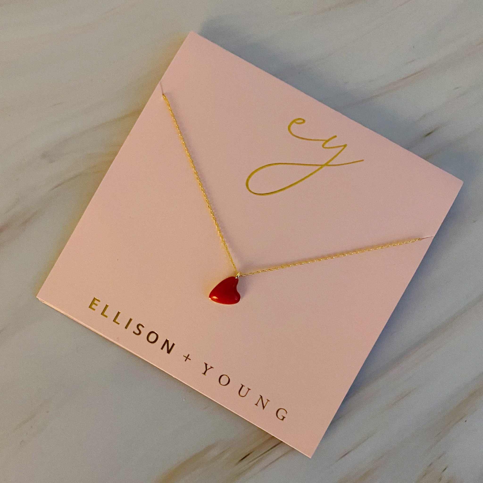 Cute colorful little heart pendant necklace on a pink presentation card, featuring a red heart charm.