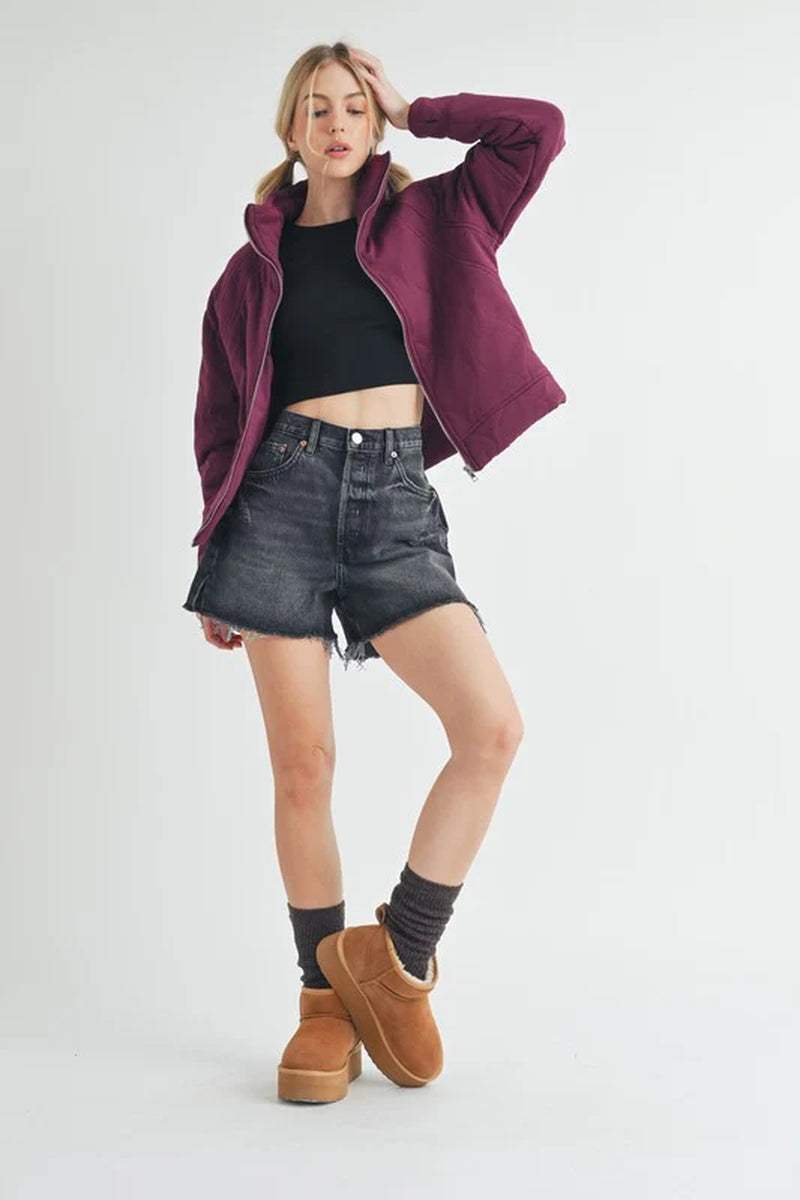 Model wearing a Darla Quilted Jacket with shorts and cozy footwear, showcasing a stylish and comfortable fall outfit.