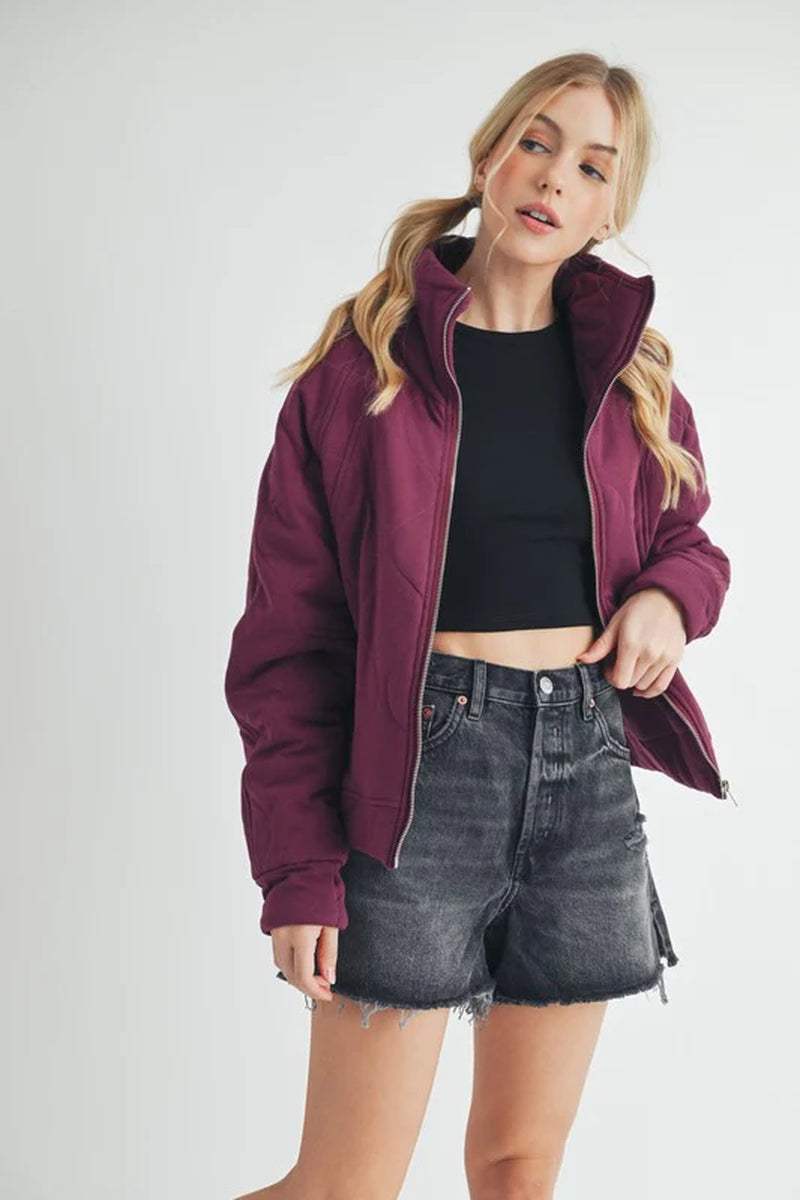 Darla Quilted Jacket in burgundy with relaxed fit, worn with a black crop top and denim shorts, perfect for stylish layering.
