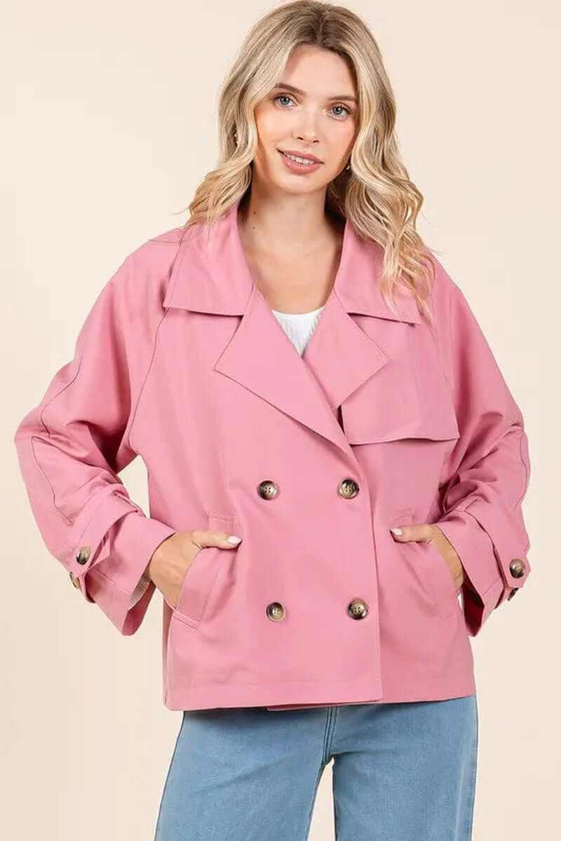 Elegant double-breasted trench coat in pink, featuring long sleeves and pockets, perfect for stylish transitional weather.