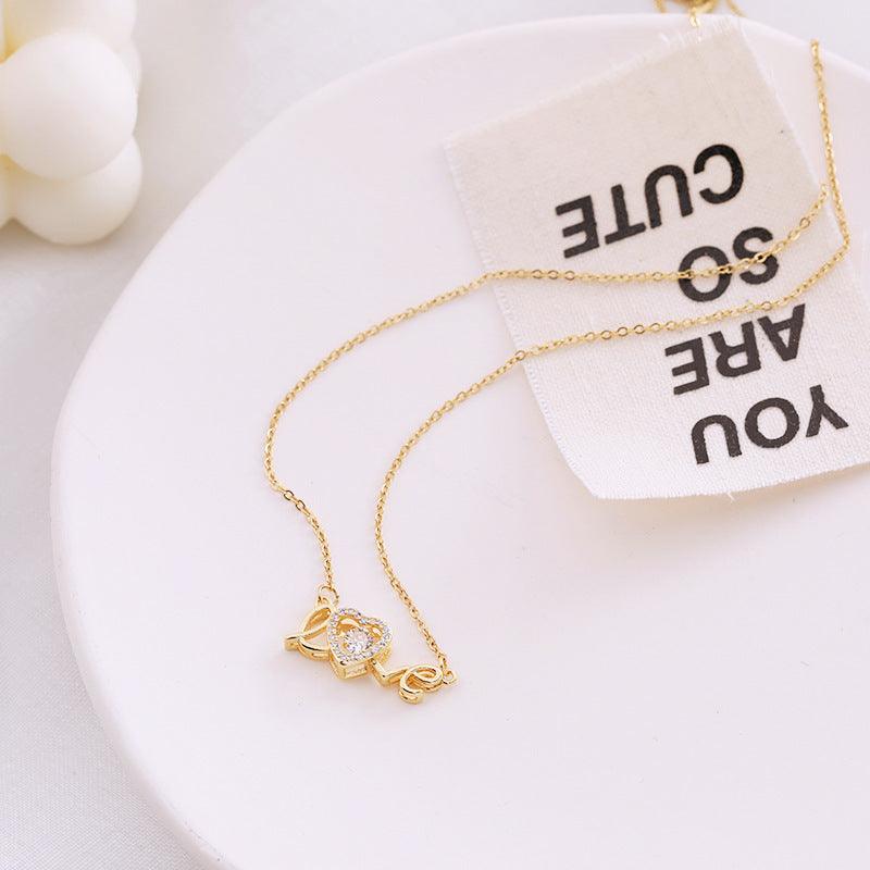 Fashion clavicle chain necklace with gold-tone heart and love pendant on white plate