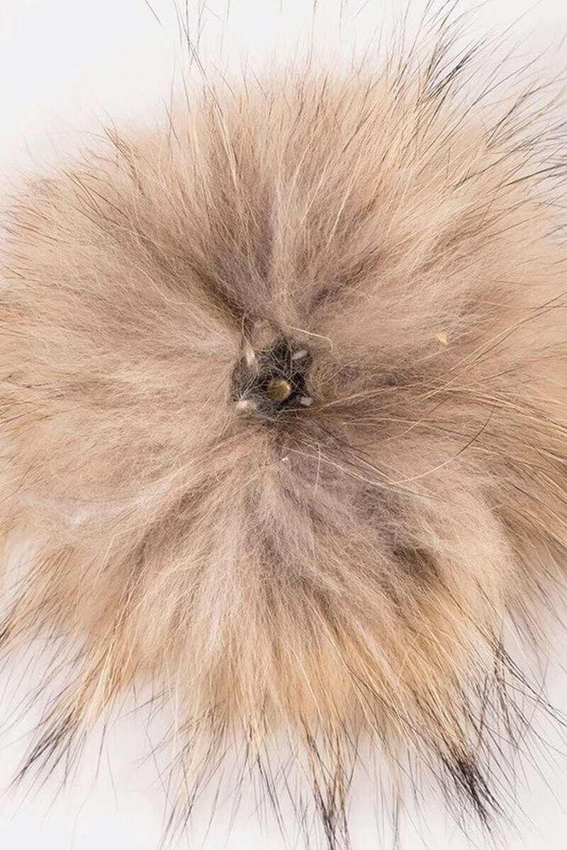 Close-up of a soft faux fur pom, perfect for hats and winter accessories, featuring a trendy light brown color.