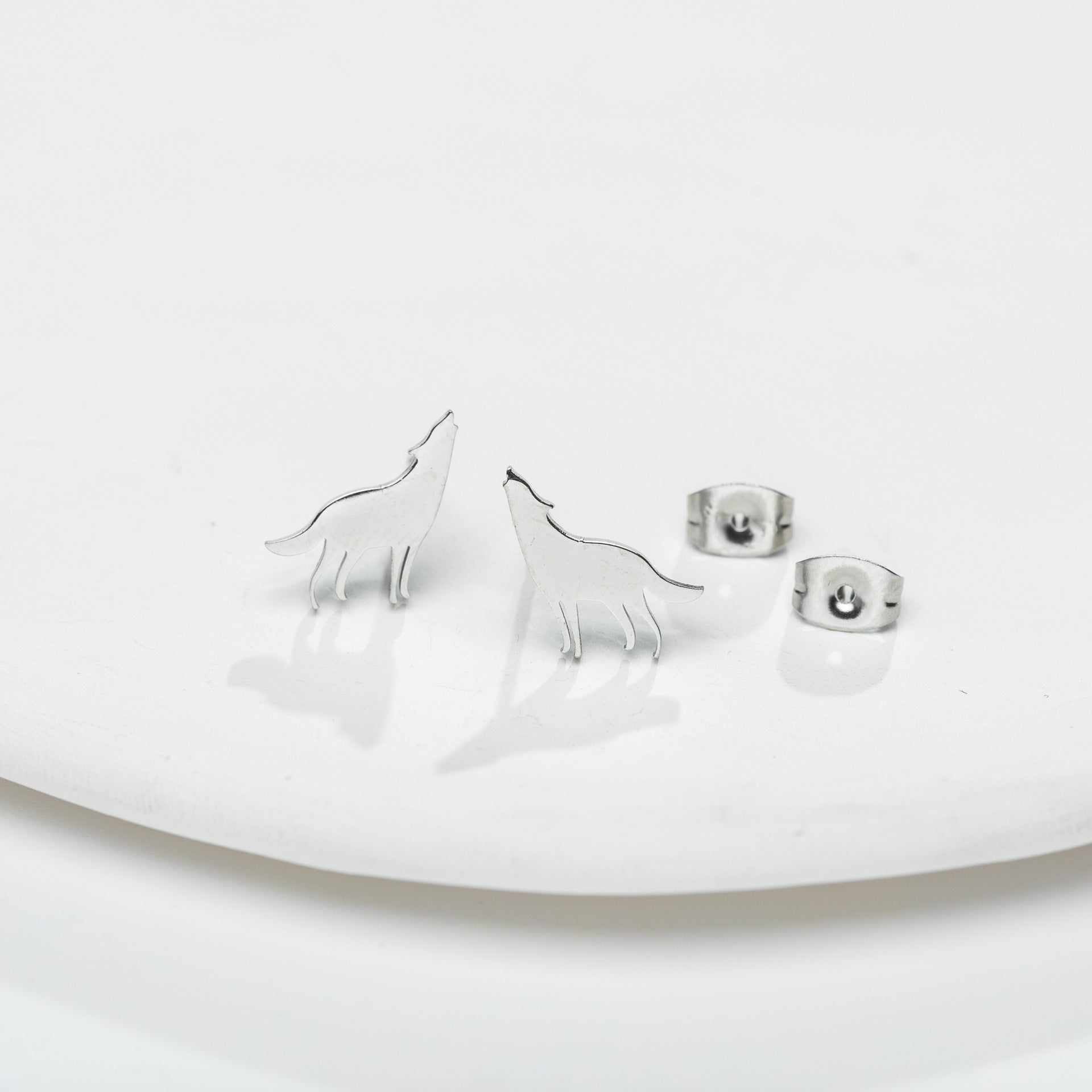 Female Japan and South Korea style small animal ear studs in stainless steel silver color on white background