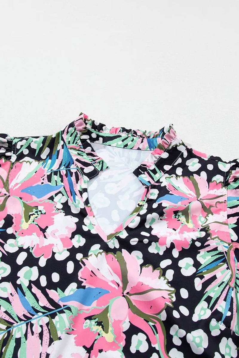 Close-up of a floral ricrac embellished mini dress featuring vibrant pink and green prints on a black background.