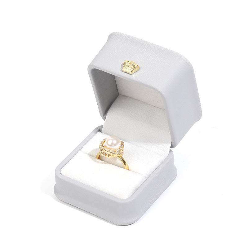 Elegant gold pearl ring displayed in a luxurious grey jewelry box, perfect for gifting or proposal.