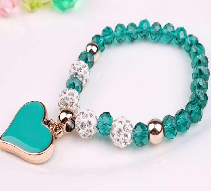 Elastic heart crystal bracelet featuring teal beads and sparkling accents, perfect for adding elegance to any outfit.