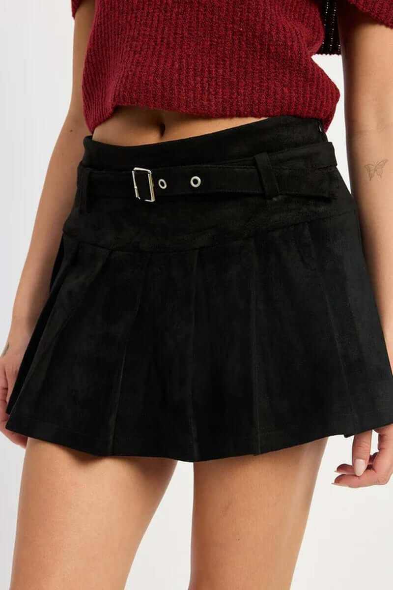 High-waisted pleated suede belted skort in black, stylish and perfect for fall fashion, worn with a cozy sweater.