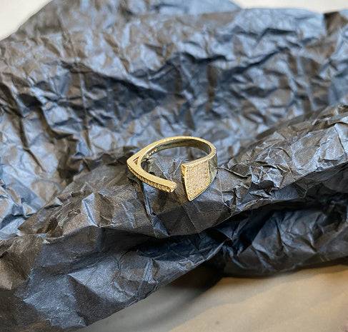 Light luxury adjustable gold index finger ring with geometric platinum inlaid gem on black textured background