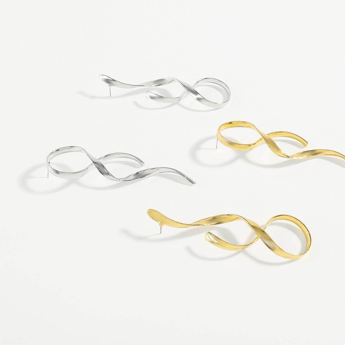 Asymmetric simple metal earrings in silver and gold with an electroplated finish