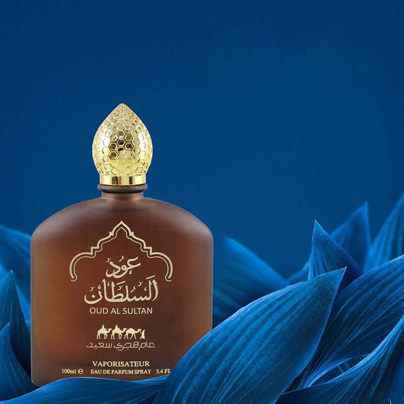 bottle of Oud Al Sultan long-lasting Middle Eastern perfume with gold cap on blue floral background