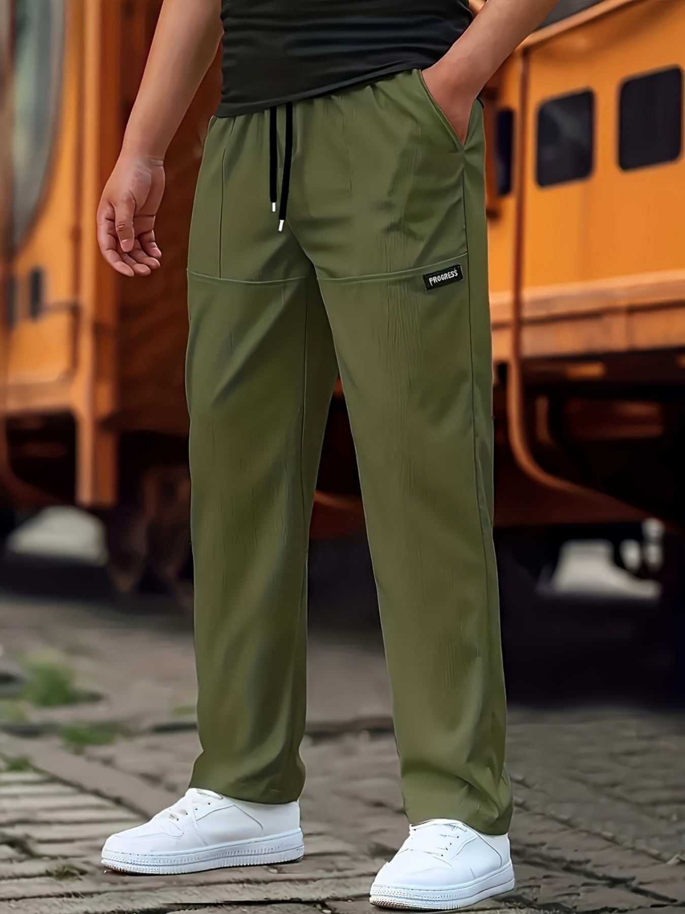 olive green men's fashion sweatpants with drawstring and pockets worn with white sneakers