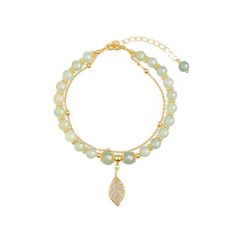 Women's Descendants of the Rich bracelet with green beads, gold chain, and leaf charm design