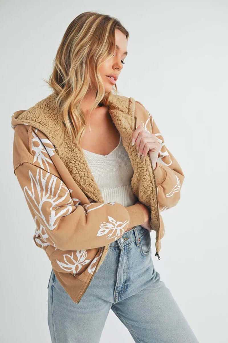 Model wearing Oita jacket with floral print, featuring a sherpa lining and oversized fit, styled with a casual outfit.