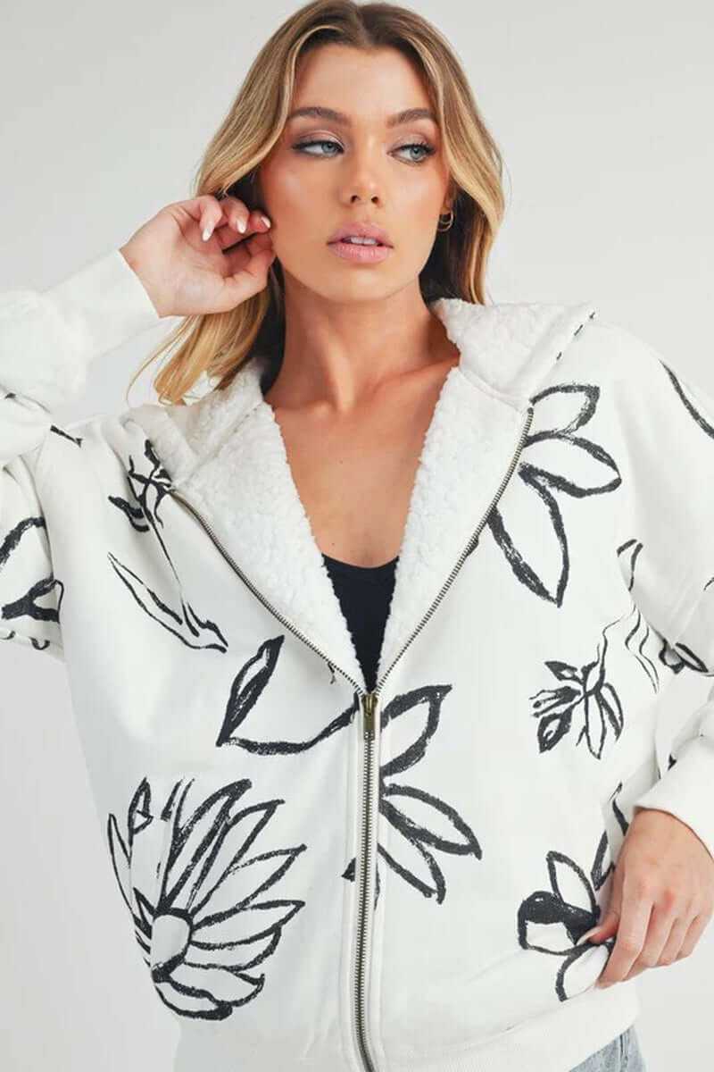 Model wearing Oita jacket with floral print, featuring sherpa lining, oversized fit, and front zip closure.