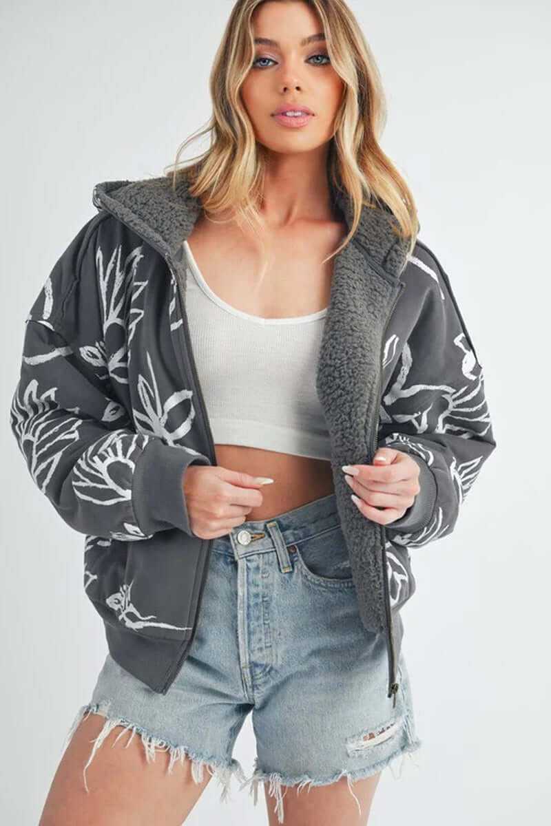 Model wearing Oita jacket with floral print, showcasing its oversized fit, sherpa lining, and comfortable style.